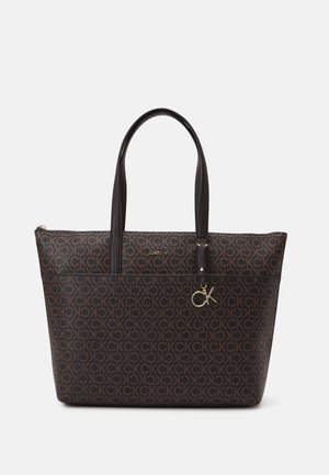 Hnědá taška Calvin Klein s opakujícím se vzorem loga "CK", dvojitými černými uchy, předním zipem kapsou a kovovým přívěskem "CK".