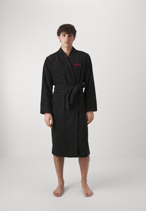 Black toweling robe with a wrap design, belt, and two side pockets. Features red "HUGO" logo on the left chest. Soft texture.