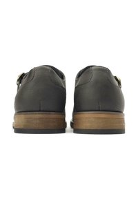 Brown leather shoes with a smooth textured finish and a wooden heel. The back features a rounded design and a brass buckle accent.