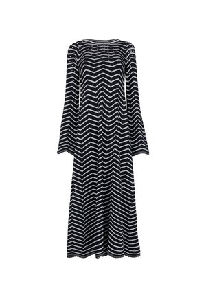 Vestido de manga larga en patrón de zigzag negro y blanco, con un escote redondeado y una tela fluida que cae hasta la mitad de la pantorrilla.