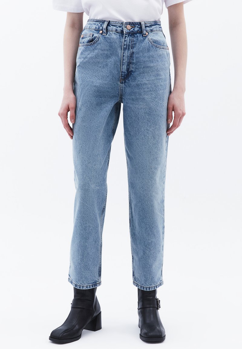 Vaaleansiniset, korkea vyötäröinen farkut suoranlahkeisella leikkauksella. Viisi taskua ja metallinen napitus. Pehmeä, teksturoitu kangas.