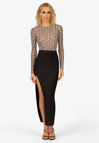 Schwarzes Kleid mit figurbetonter Silhouette, transparenten langen Ärmeln mit geometrischem Muster und einem hohen Schlitz bis zum Oberschenkel. Glatte Textur überall.