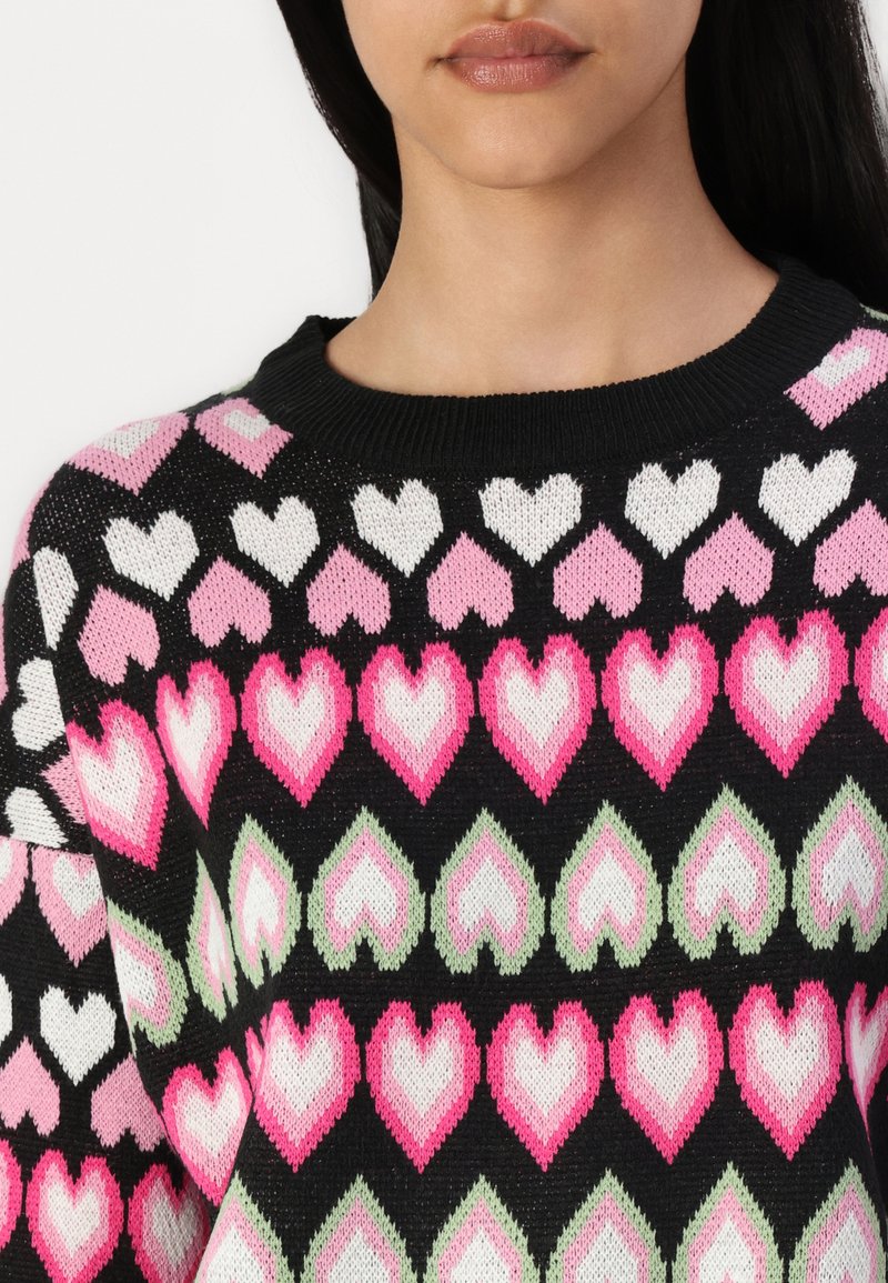 Maglione nero con un motivo di cuori intrecciati in rosa, bianco e verde. Collo a costine ben definito e vestibilità ampia.
