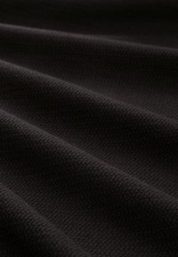 Tissu noir texturé avec un motif tissé, mettant en valeur des plis lisses et ondulants ainsi qu'une finition mate.