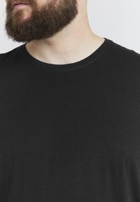 Black short-sleeve t-shirt with a crew neckline, made of smooth cotton fabric, featuring a plain design without patterns or accents.