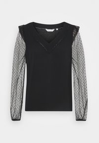 Mustat yläosa V-avauksella, jossa on läpikuultavat harmaat pilkulliset pitsihihat ja joustavat hihansuut. Teksturoitu pitsireuna kaula-aukossa.