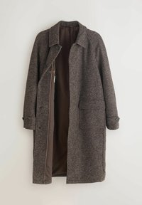 Pikk pruun tweed mantel, millel on lai krae, nupudega varrukad, suur esikott ja lahti jääv eesmine osa, mis paljastab sileda pruuni voodri.