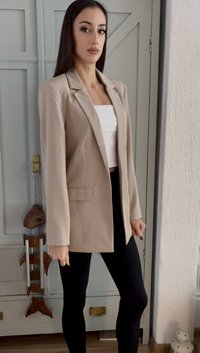 Beige tailored blazer with a standard collar, front pockets, and long sleeves, paired with black leggings. Smooth texture, lightweight fabric.