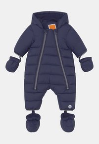 Tummansininen vauvan talvipuku, jossa on kiinteä huppu, lapaset, tossut, kaksinkertaiset etuvetoketjut ja Timberland-logo vasemmassa jalassa.