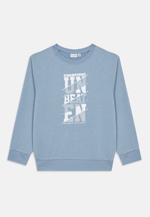 Lyseblå hettegenser laget av mykt stoff, med et grafisk design i hvit tekst som inkluderer "CHAMPIONS" og "UNBEATEN" i fet skrift.