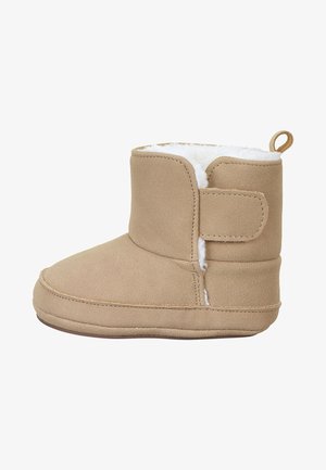 Tan, faux suede boot with a soft, white, plush lining, low ankle height, rounded toe, and side Velcro strap for secure closure.