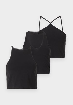 Drie zwarte cropped tanktops met verschillende halslijnen: hoge hals, ronde hals en gekruiste bandjes, uitgestald op een witte achtergrond.