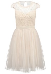 Beige mekko, jossa istuva yläosa ja kerroksellinen tyllihame. Yläosassa on läpikuultava helmiäiskoristeinen päällyste ja avonainen selkäosa.