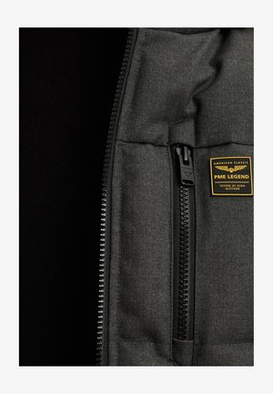 Zwarte zip-up jas van een gemêleerde stof. Heeft een zak met een zwarte rits en een rechthoekig label met de "PME LEGEND" branding.