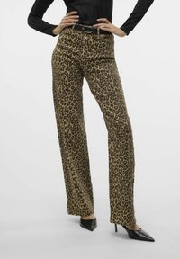 Luipaardprint broek gemaakt van gladde stof, met een hoge taille en wijde benen, gecombineerd met elegante zwarte puntige hakken.