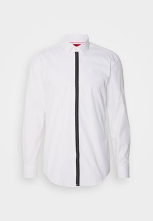 Λευκό πουκάμισο με μακριά μανίκια και μαύρη κάθετη ρίγα μπροστά, με γιακά από κουμπί και λεία υφή.