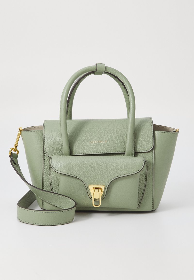 Sac à main en cuir vert avec un design structuré, deux poignées supérieures, une longue bandoulière et des éléments en or. Présente un rabat avant et une surface texturée.
