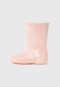 Botte de pluie en caoutchouc rose avec une finition brillante. Tige courte, semelle texturée et motif en relief sur le côté. Design léger et flexible.