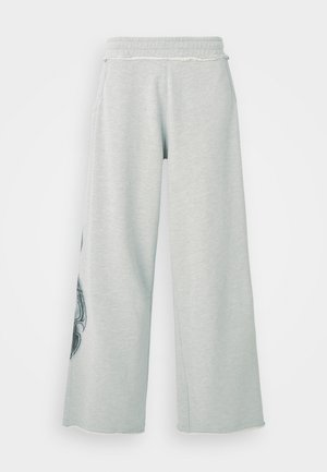 Lys grå vide ben sweatshirtbukser laget av myk bomullsmiks, med sidelommer og en dekorativ svart grafikk på venstre ben.