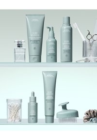 La collection de produits Aveda Scalp Solutions comprend des flacons et tubes vert clair avec du texte blanc, comprenant un revitalisant, un shampooing et un traitement du cuir chevelu.