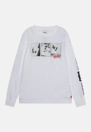 Wit shirt met lange mouwen met drie zwart-wit skateboardfoto's over de borst en het "Levi's" logo in het rood onder de rechterfoto.