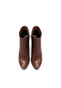 Stivali alla caviglia in pelle marrone con design elegante, punta appuntita e doppie cerniere su ciascun lato per la chiusura. Texture liscia e colore uniforme.