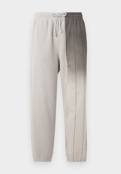 Light gray joggers featuring a drawstring waistband, soft texture, and a gradient from light to dark gray with vertical stitching accents.