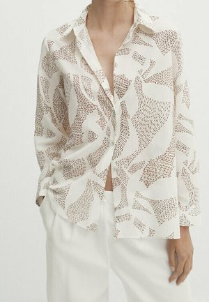 Blouse légère couleur crème avec motifs abstraits marron, boutonnée à l'avant, manches longues, coupe décontractée et texture drapée.