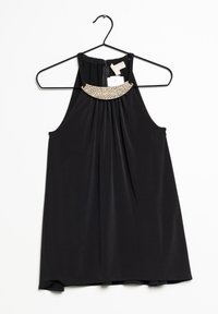 Haut sans manches noir en halter avec des plis et des embellissements en texture dorée au niveau du décolleté, suspendu sur un cintre noir contre un fond blanc.