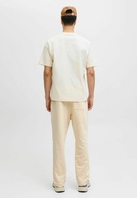 Lyse farvet bomulds t-shirt og sweatpants sæt; t-shirten har korte ærmer og en afslappet pasform; sweatpantsene har en baglomme og tapered ben.