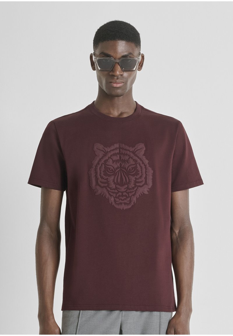 Bordo majica kratkih rukava od pamuka s istaknutim reljefnim dizajnom tigrove glave na prednjem dijelu. Klasičan okrugli izrez.