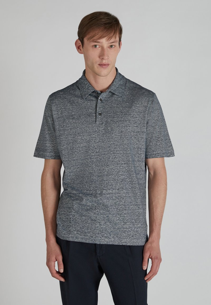 Koszula polo z krótkim rękawem w ciemnoniebieskim kolorze z delikatnym teksturowanym wzorem, trzema guzikami z przodu oraz klasycznym kołnierzykiem. Wykonana z lekkiego materiału.