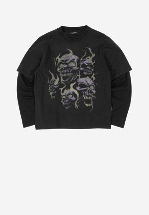 Juodas sluoksniuotas ilgomis rankovėmis marškinėliai su grafika, kurioje pavaizduoti penki purpuriniai kaukolės aplinkoje geltonai žalių liepsnų, ant priekio.