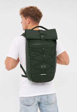 Mörkgrön ryggsäck med rulltoppsdesign, framficka med dragkedja, justerbara remmar och detaljer av bungee-kord. Tillverkad av slitstift tyg.