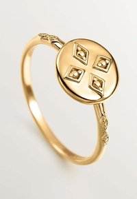 Anillo de oro con una base circular que presenta un diseño de cruz elevada, con acentos en forma de diamante y una banda intrincadamente diseñada.