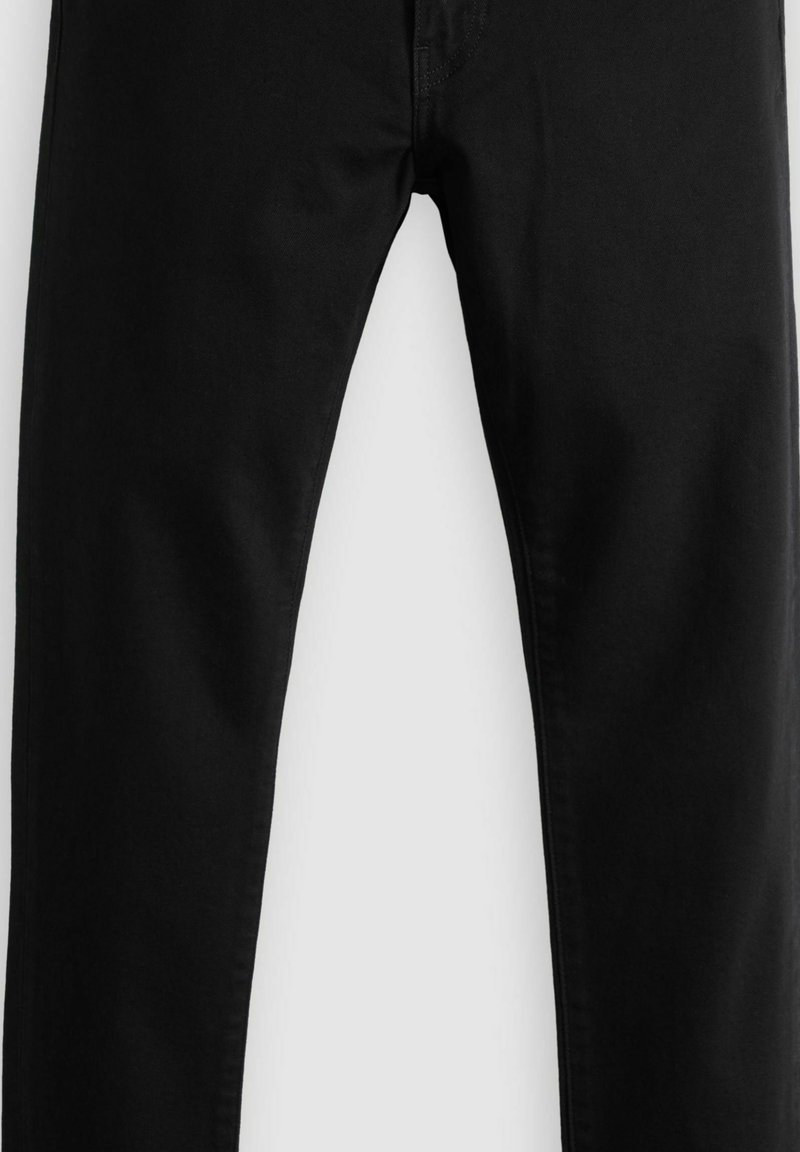 Pantalon noir à jambes droites avec coutures apparentes et une texture de tissu propre et lisse.