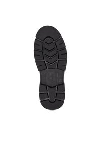 Soletta in gomma nera con superficie texturizzata e scanalature profonde e angolari per la trazione. Presenta un tallone liscio con etichetta del marchio.