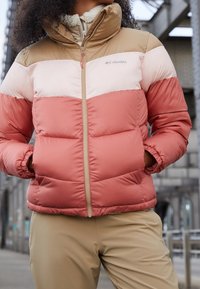 Kurtka puchowa z zamkiem z przodu, z designem w blokach kolorów różowego, kremowego i beżowego. Gładka faktura, wysoki kołnierz i prążkowane mankiety.