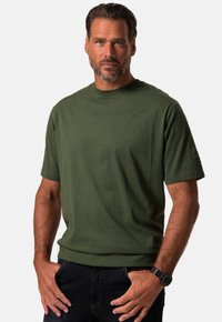 Grøn crew-neck t-shirt i bomuld med en glat tekstur og korte ærmer. Bemærkelsesværdig detalje: logo på venstre ærme.