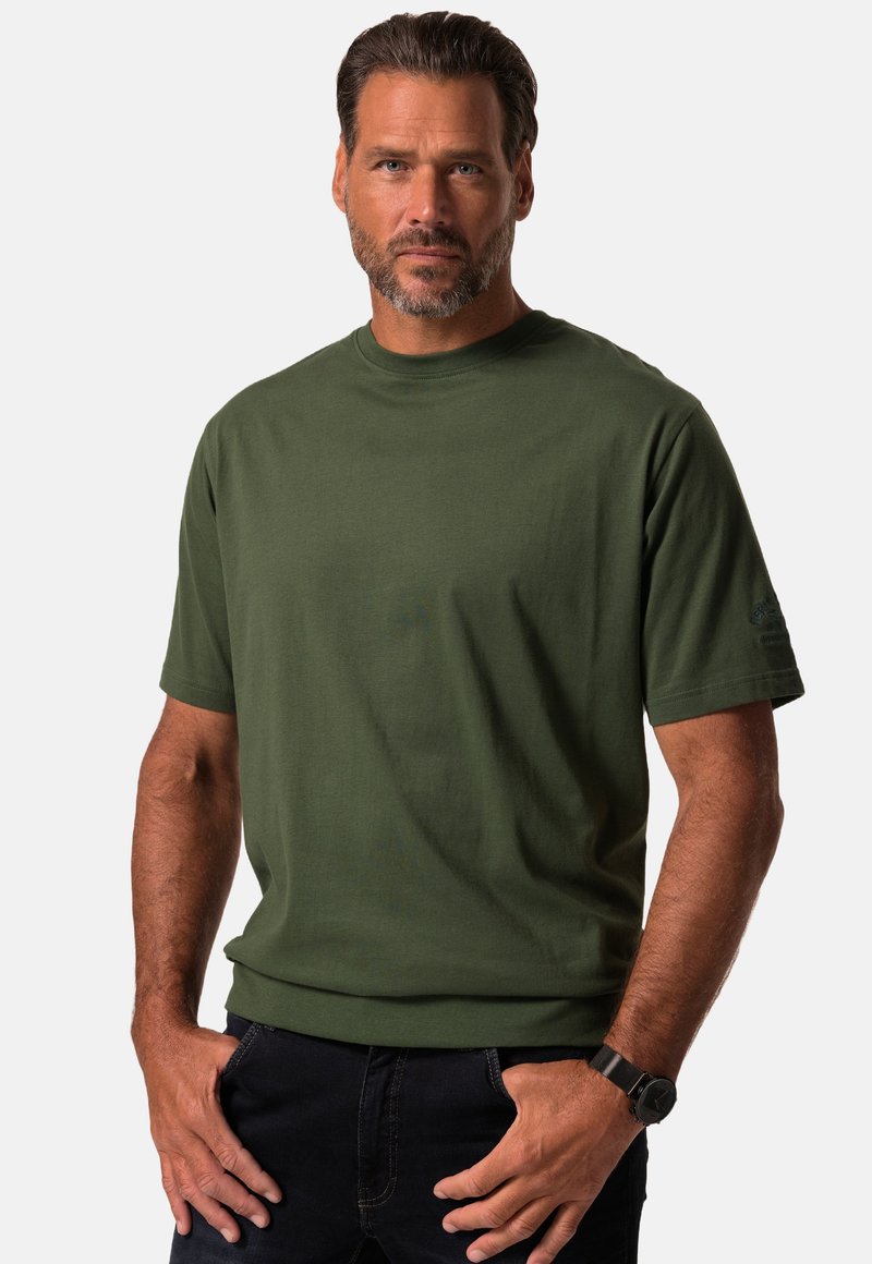 Grøn crew-neck t-shirt i bomuld med en glat tekstur og korte ærmer. Bemærkelsesværdig detalje: logo på venstre ærme.