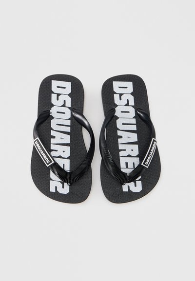 Μαύρες λαστιχένιες σαγιονάρες με υφασμένη σόλα, με μεγάλο λευκό λογότυπο "DSQUARED2" στους ιμάντες και στις εσωτερικές σόλες.
