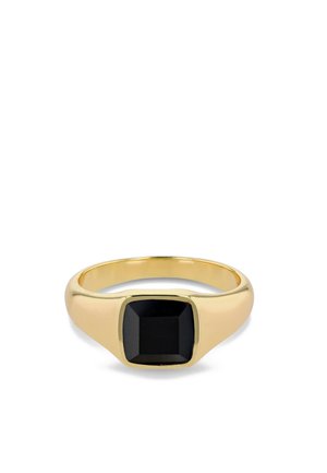 Anillo de oro con una banda ancha que presenta una piedra negra facetada y de forma cuadrada en el centro.