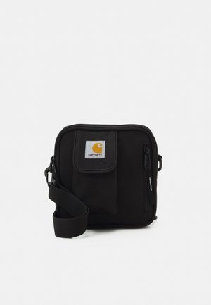 Sac bandoulière noir Carhartt avec poche avant, compartiment zippé et sangle d'épaule réglable.