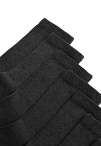 Calcetines negros hechos de una tela suave y texturizada. Tienen un borde acanalado y un acabado liso, dispuestos en una disposición apilada.