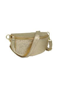 Sac bandoulière métallisé doré avec fermeture éclair, bandoulière ajustable et texture lisse, de forme arrondie. Souligné par des accessoires en or.