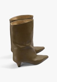 Un par de botas de cuero marrón hasta la mitad de la pantorrilla con punteras puntiagudas y bajos tacones de kit, mostradas una al lado de la otra sobre un fondo blanco.