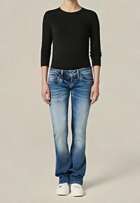 Czarna bluza z długim rękawem połączona z jasnoniebieskimi dżinsami z wyblakłymi przodami i pięcioma kieszeniami, dopełniona białymi butami.