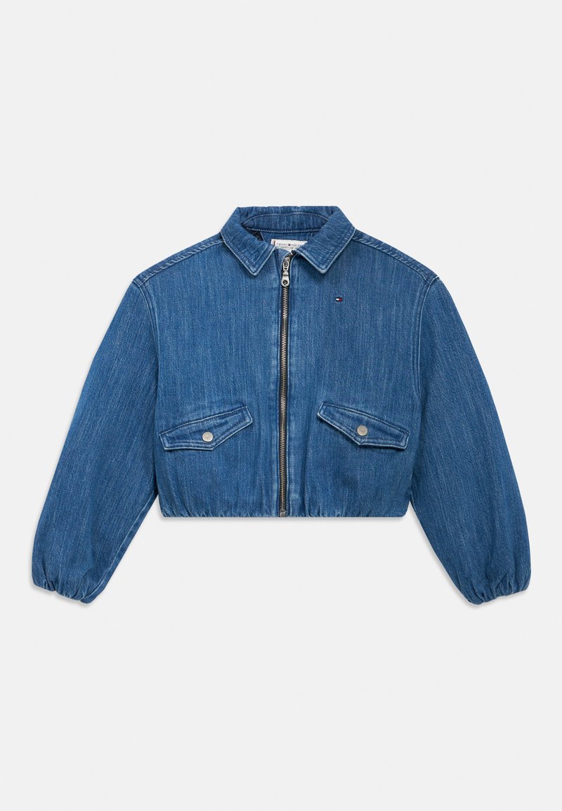 Κοντό τζιν μπουφάν σε μέτριο μπλε, με εμπρόσθιο φερμουάρ, δύο τσέπες στο στήθος με κουμπιά και ελαστικές μανσέτες.