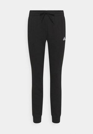 Pantalons de jogging noirs en tissu doux, avec une taille élastique à cordon de serrage et des poignets aux chevilles ; petit logo blanc sur la jambe gauche.