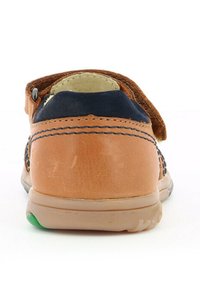 Scarpa in pelle marrone con accenti blu navy, texture liscia, cinturino in velcro e una linguetta verde in gomma sulla suola, progettata per comfort e supporto.